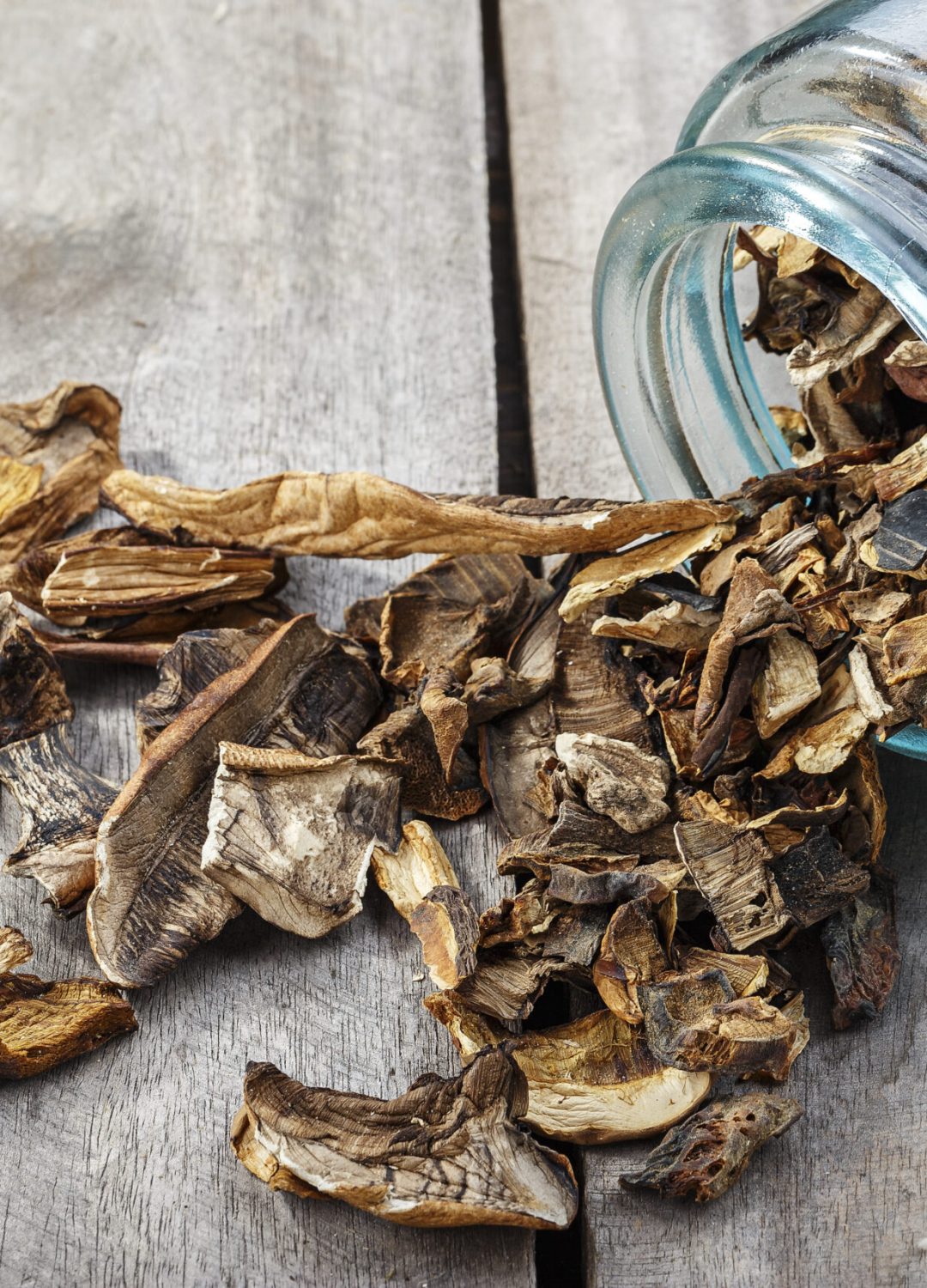 Dried mushrooms in a jar, sliced dried boletus on a wooden background