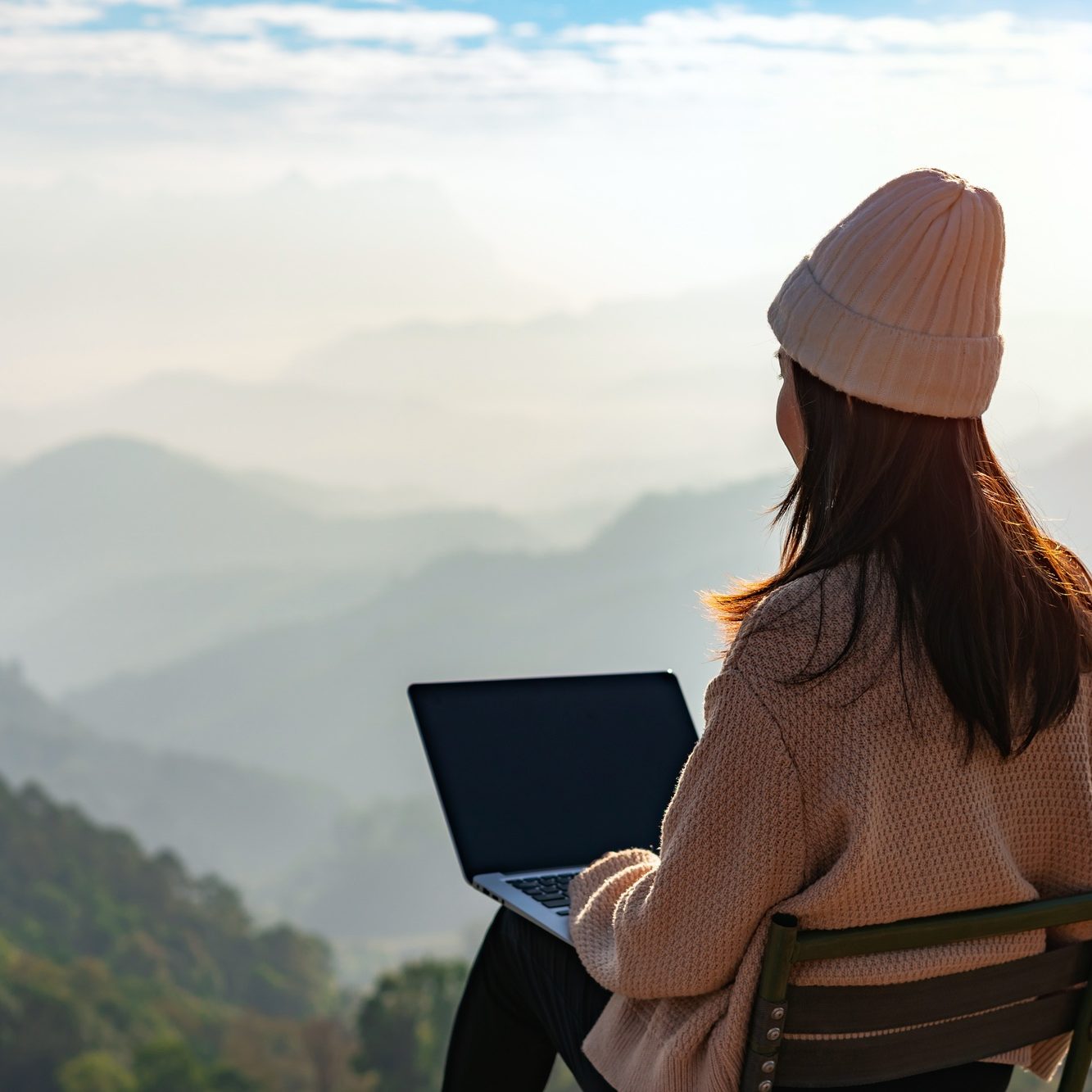 Young woman freelancer working online using laptop and enjoying the beautiful nature landscape Young woman freelancer working online using laptop and enjoying the beautiful nature landscape